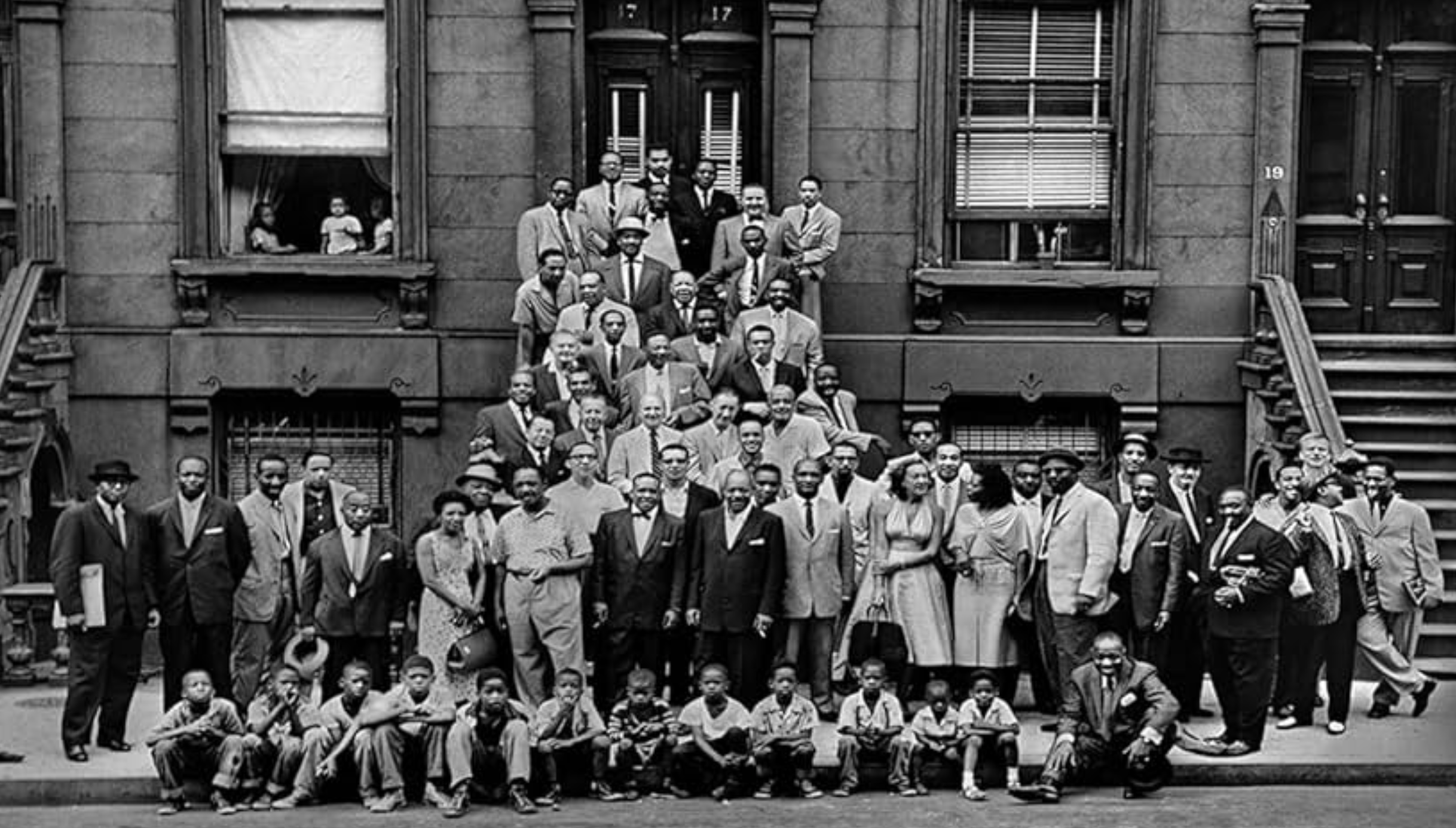 A Great Day in Harlem, image taken by Art Kane in 1958. Jazz musicians standing and sitting on a porch in Harlem New York.